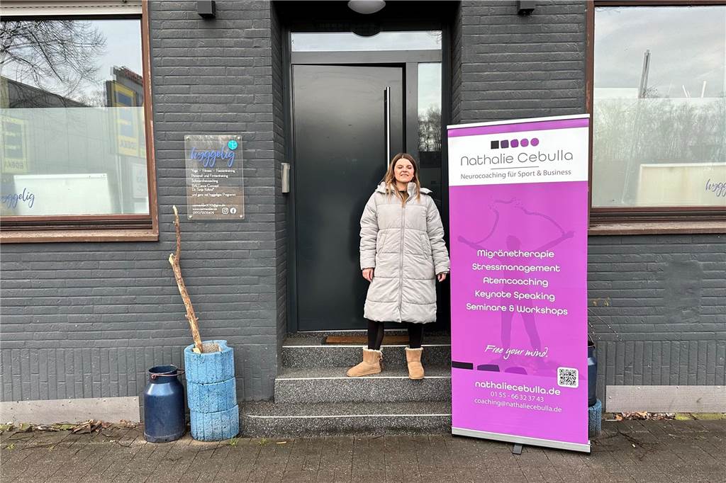 Studio „Hyggelig“ zum Mieten: Nathalie Cebulla gibt ab sofort Kurse Nathalie Cebulla steht im Eingang des Studios "Hyggelig" in Schwerte. Neben ihr steht ein Plakat, das auf ihre Angebote hinweist.