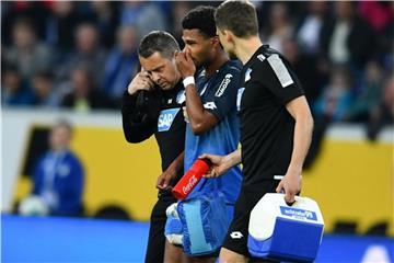 Nationalspieler Serge Gnabry (M) wird verletzt von zwei Hoffenheimer Betreuern vom Platz begleitet. Foto: Uwe Anspach/dpa