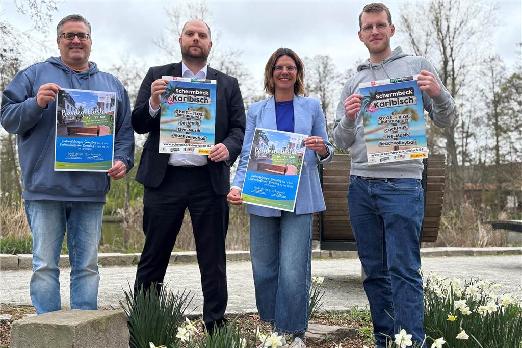 Volles Mai-Programm: Schermbeck Karibisch trifft Bankgeflüster Frank Herbrechter (Werbegemeinschaft),Tim Scholz (Nispa,) Sabrina Greiwe (Wirtschaftsförderung) und Simon Stemmer (Veranstalterteam Beach Projekt) stehen gegenüber des Rathauses in Schermbeck und halten Plakate für die Veranstaltung.