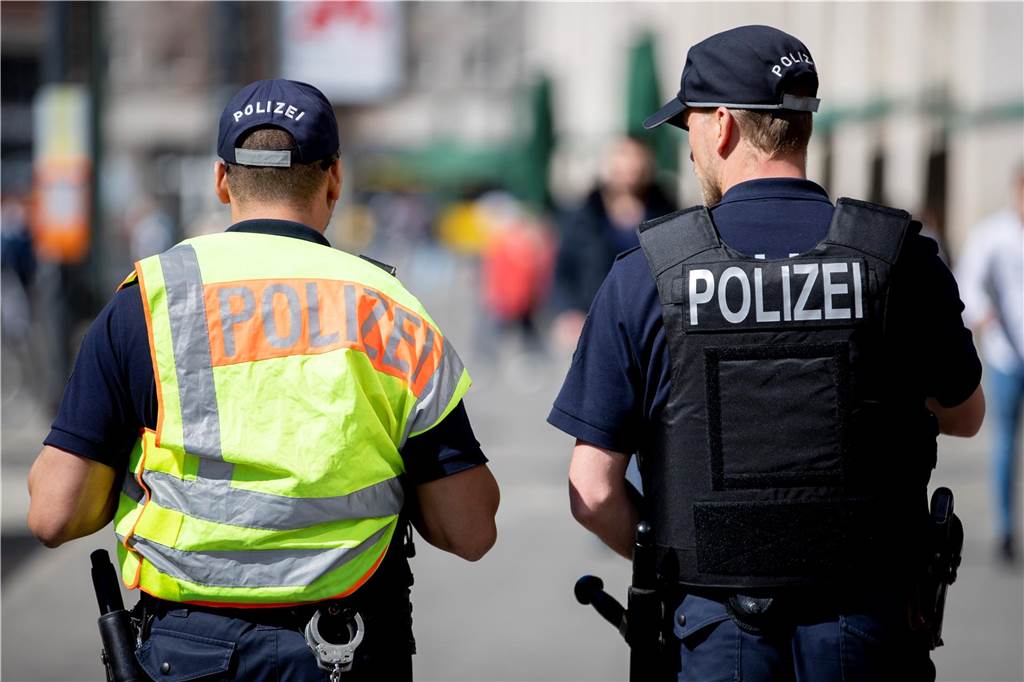 Sicherheit beim Bottroper Karneval: Ein Kraftakt für die Beteiligten Zwei Polizisten auf Streife, von hinten fotografiert