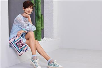 Netzsöckchen - hier in Kombination zu einem sommerlichen Sneaker mit floralem Design und Satin-Schnürsenkeln von Deichmann - sind der neue Trend (Schuh ca. 23 Euro, Clutch ca. 10 Euro). Foto: Deichmann