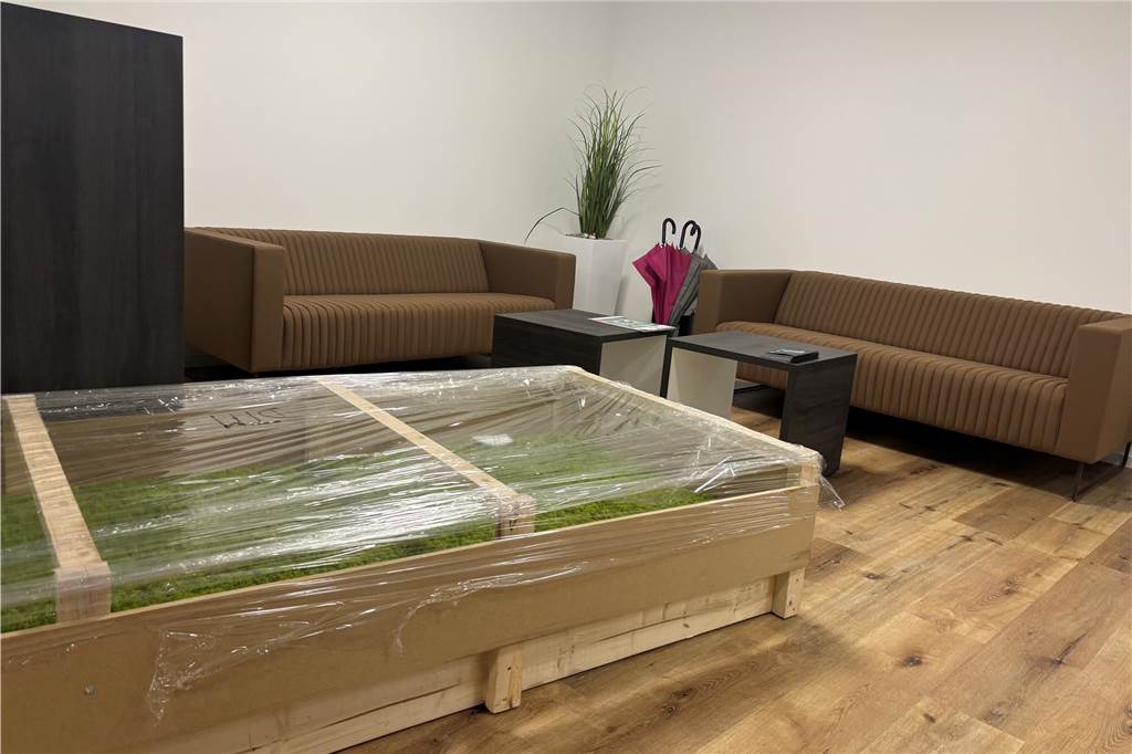 Volksbank öffnet im neuen Gewand: Bekenntnis zu Standort am Biesenkamp Neu hinzugekommen ist ein Wartebereich für Kunden. Er besteht aus zwei bräunlichen Sofas und zwei kleinen schwarzen Tischchen. Noch eingepacktes Moos soll dekorativ an die Wand angebracht werden.