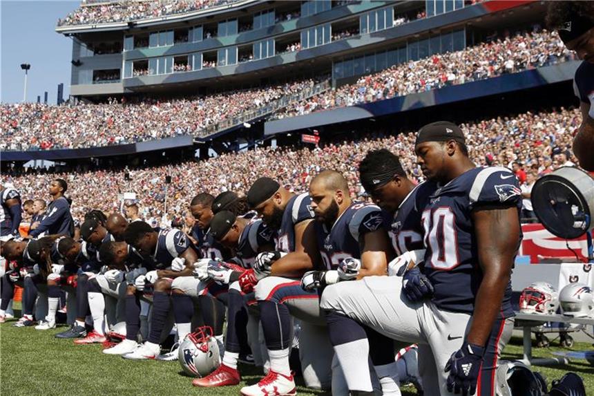 Sitzen, Knien, Unterhaken: Solidarität für NFL-Profis NFL-Spieler der New England Patriots protestierten während der US-Nationalhymne. Foto: Michael Dwyer