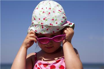 Nicht nur im Sommer sollten Kinder lieber nur mit Kopfbedeckung in die Sonne. Ihre Augen schützt eine Sonnenbrille mit UV-Filter. Foto: Silvia Marks