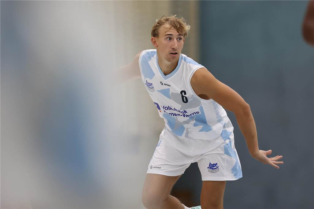 LippeBaskets überzeugen gegen Top-Team Ein Basketballspieler mit weißem Trikot steht gebeugt auf einem Feld.