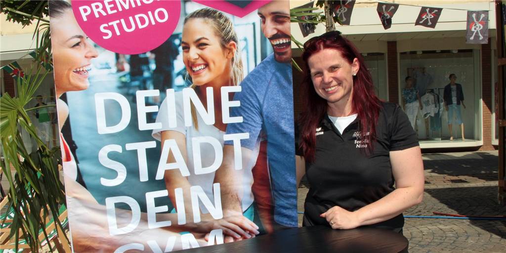 Eine Frau steht neben einem Plakat auf dem Marktplatz Werne.