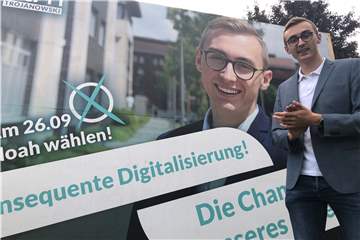 Noah Trojanowski vor seinem Wahlplakat an der B1. Bei dem Fototermin hupten vorbeifahrende Autos.