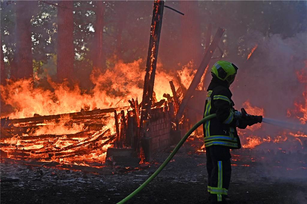 Ein Feuerwehrmann vor Flammen.