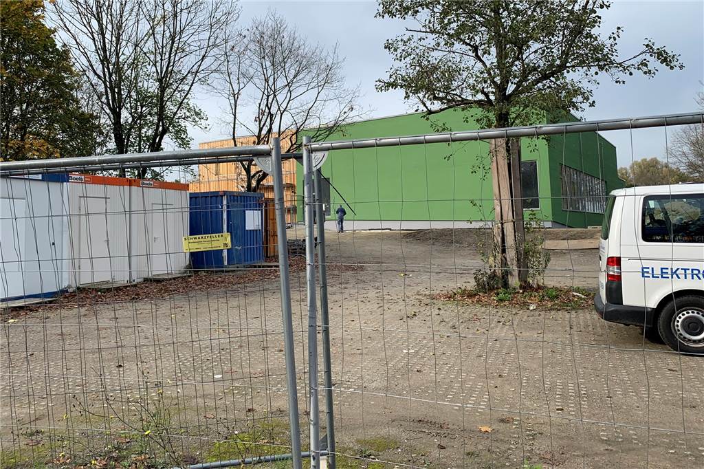 Container und Bauzäune stehen auf dem Gelände des Westbad-Neubaus im Revierpark Wischlingen. Im grünen Gebäude entsteht das neue Westbad.