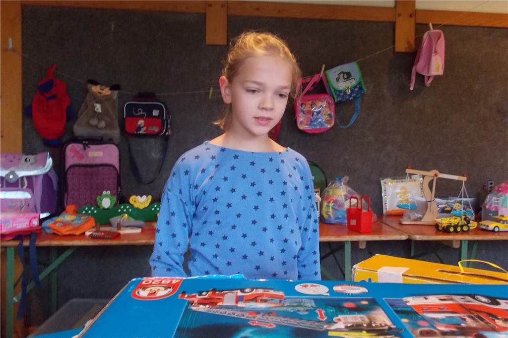 Verführerische Preise und prall gefüllte Einkaufstaschen Nora interessierte sich für das angebotene Spielzeug.