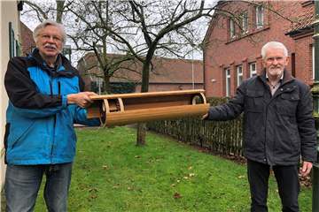Norbert Sabellek (l.) und Alois Grünewald vom Heimatverein mit einer Röhre, die im Querschnitt die Nisthilfe für Steinkäuze zeigt. An einer von 14 solcher Röhren, die der Heimatverein in Erle an Bäumen angebracht hat, gelang Grünewald sein prämiertes Naturfoto.