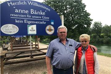 Norbert und Bärbel Linneweber vor ihrem Biergarten am Kanal: Sie distanzieren sich aufs Schärfste von AFD-Bürgermeisterkandidat Marco Bühne, der sich ohne ihre Kenntnis unter ihrem Begrüßungsschild für die Dorstener Zeitung ablichten ließ.