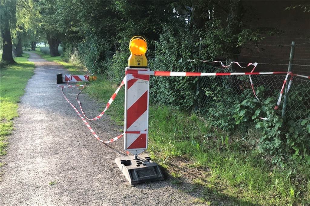Flatterband und Stütze: Birgt Riss in Bauhofwand am Uferweg eine Gefahr? Notdürftig mit Flatterband abgesperrt ist der Bereich rund um die beschädigte Wand. Ein Teil des stark frequentierten Uferwegs entlang der Schlinge wird damit genommen. Das soll sich bald ändern, teilt die Gemeinde mit.