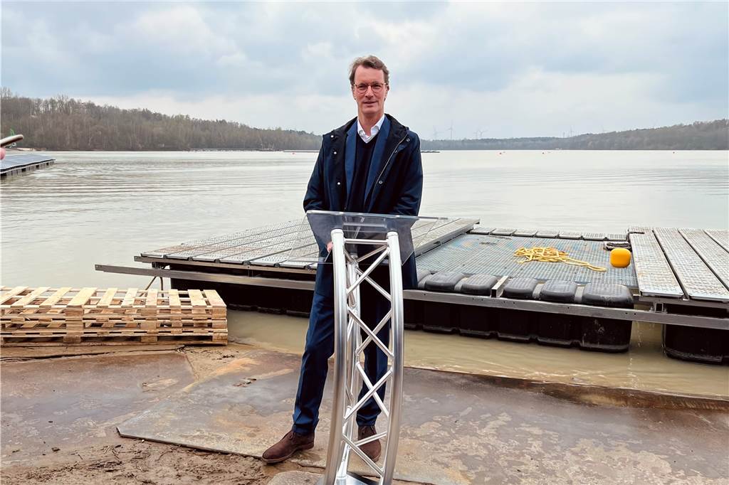 Hendrik Wüst packt bei riesiger Silbersee-Solaranlage in Haltern mit an Hendrik Wüst am Rednerpult vor dem Silbersee.