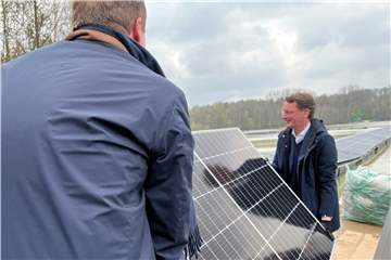 Hendrik Wüst packt ein Solarpanel an.