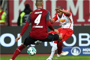 Nürnbergs Ewerton (l) blockt im Spiel gegen Jahn Regensburg einen Ball von Jann George. Foto: Daniel Karmann