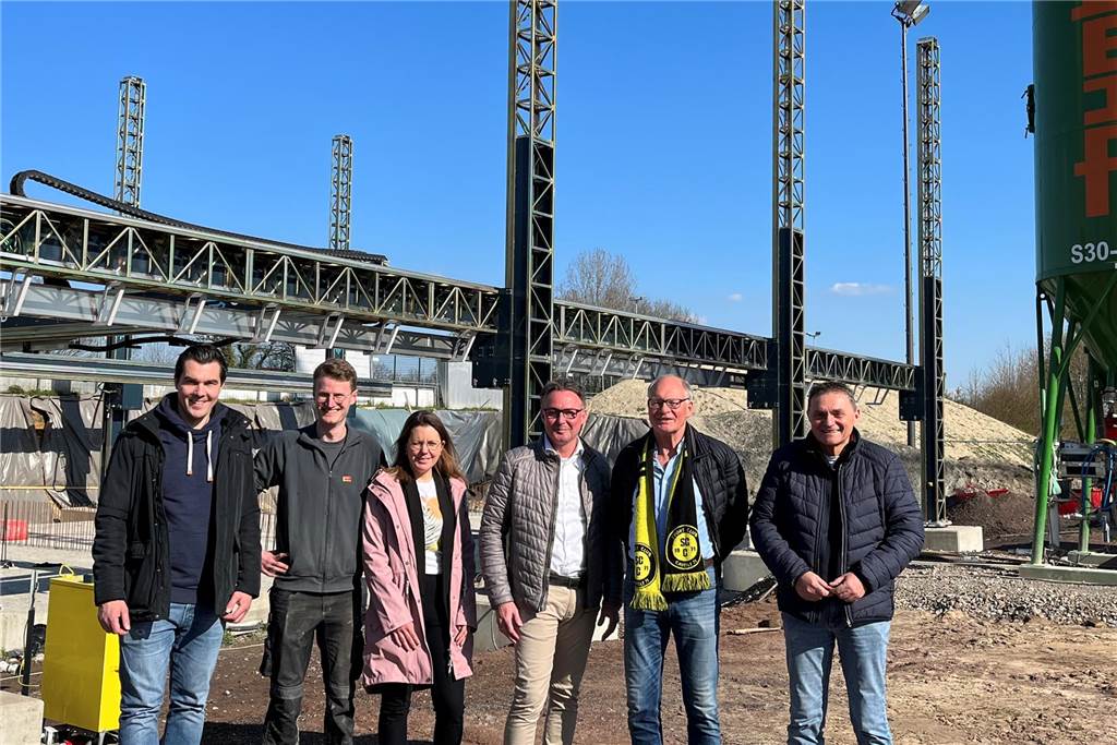 3-D-Vereinsheim in Capelle wird 2023 fertig: Baustart steht bevor Nun geht es mit dem 3-D-Druck in Capelle los. Beim Vorort-Termin war die Vorfreude (v.l.) Bauamtsleiter Manuel Lachmann, Michael Oßwald (Peri), Daniela Kuropka und Lothar Steinhoff (Architekturbüro), Josef Merten (SC Capelle) und Bürgermeister Dietmar Bergmann anzumerken. Hier stehen sie vor dem gewaltigen Drucker.