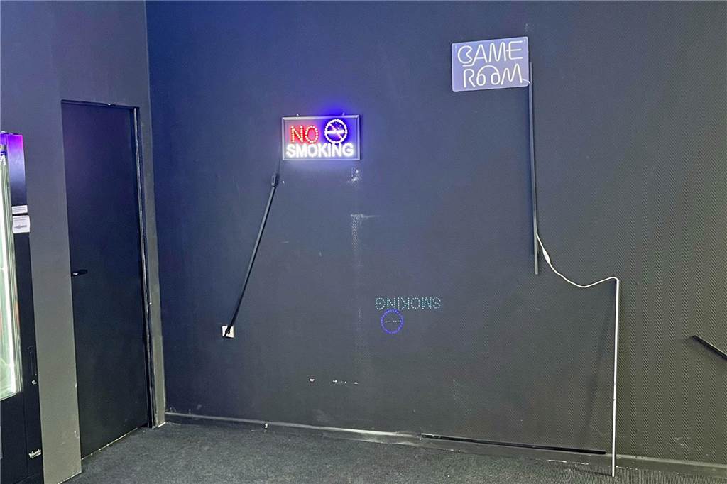 Automaten-Kiosk ohne Automaten? Veränderungen Am Griesetorn Ein eingeschaltetes Leuchtschild, auf dem „No Smoking“ steht, und eine ausgeschaltete Reklame „Game Room“ an der Wand des Kiosks in Werne