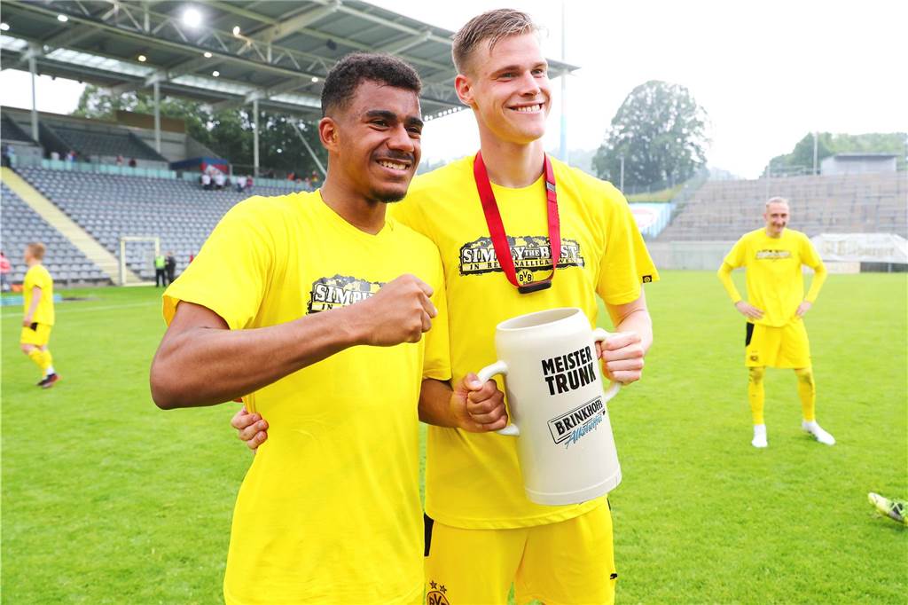 BVB-Talente und der zweite Bildungsweg: „Das ist das genau das, wofür unsere U23 stehen soll“ Ansgar Knauff und Steffen Tigges halten einen Bierkrug.