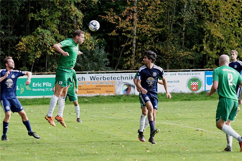 Oberadens Peter Sokol (2.v.l.) steht in der Luft und klärt den Ball aus dem eigenen Sechzehner.