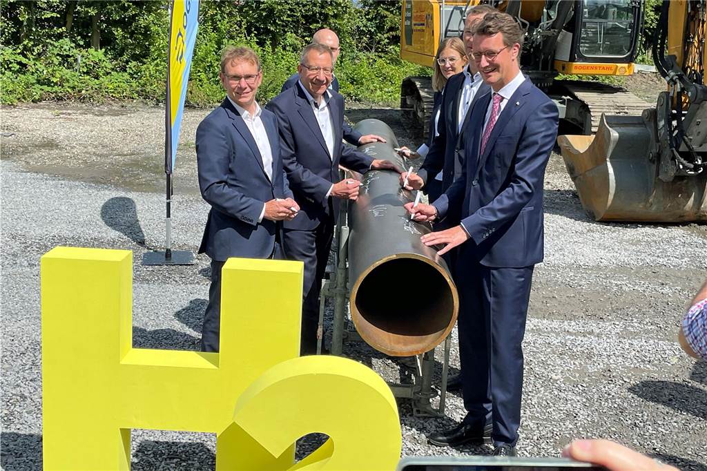 Offizieller Spatenstich am Wasserstoff-Rohr. (V. l.) Bürgermeister Lothar Christ, Dr. Jörg Bergmann und Dr. Thomas Hüwener (verdeckt, OGE-Geschäftsführung) sowie Ministerpräsident Hendrik Wüst.