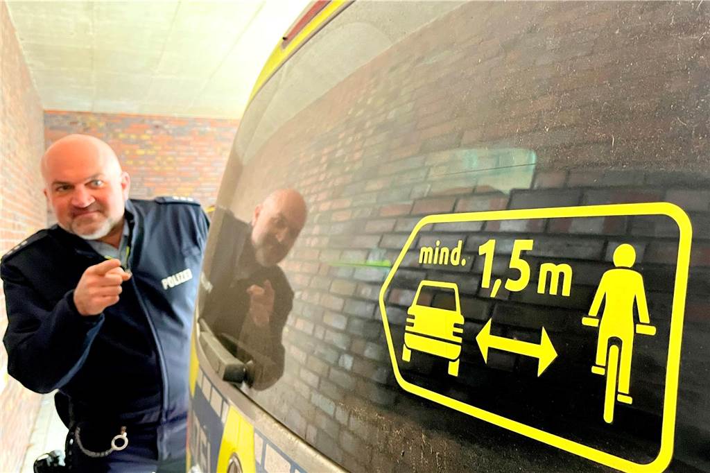 Helmpflicht für Pedelecs: Verkehrssicherheitsberater hätte nichts dagegen Jan Tonke weist auf den Hinweis zum Mindestabstand zwischen Autos und Radfahrern. Auf jedem Streifenwagen weist die Polizei darauf hin.
