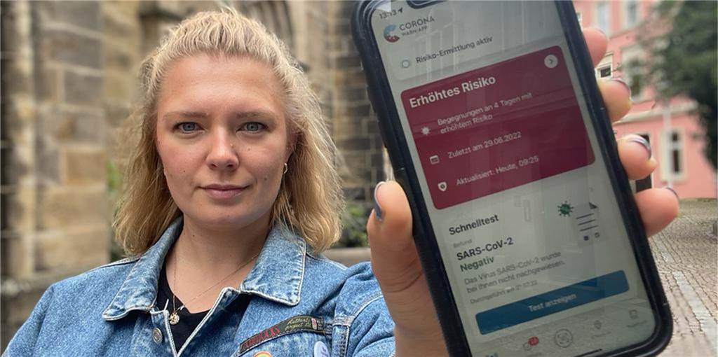 Corona-Schnelltest: Holpriger Start der 3-Euro-Regel in Castrop-Rauxel Frau hält Smartphone mit roter Corona-Warn-App in der Hand