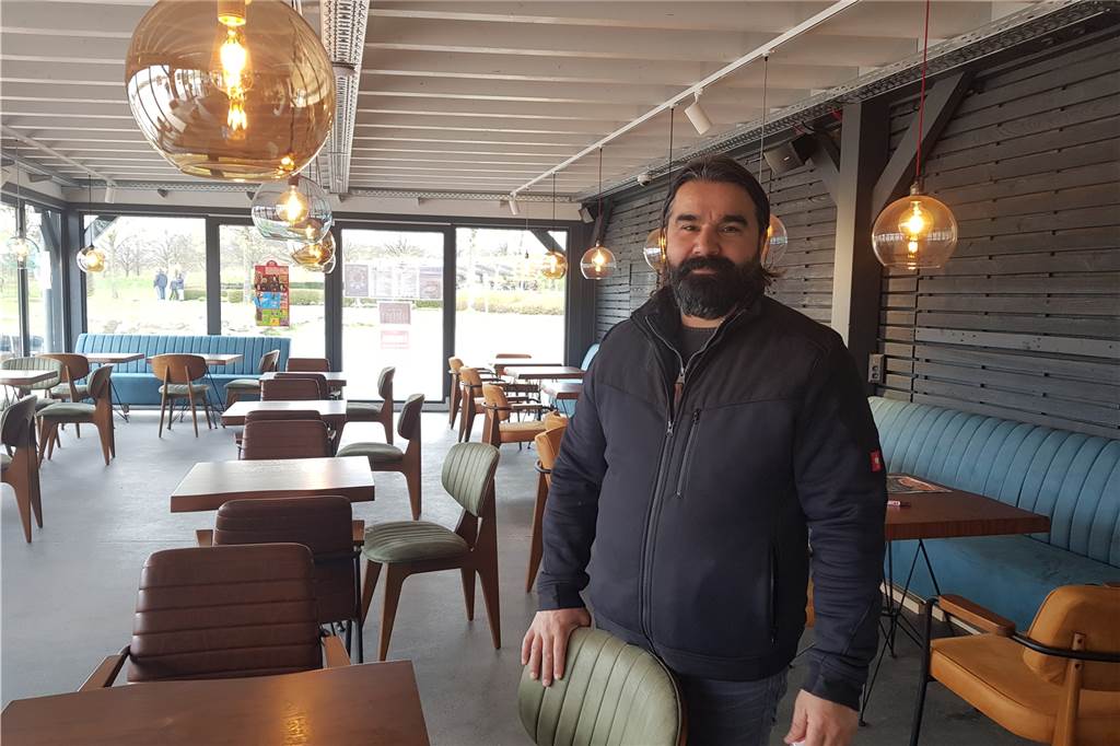 Okay Sen würde seinen Gästen gerne einen Platz im Café anbieten.