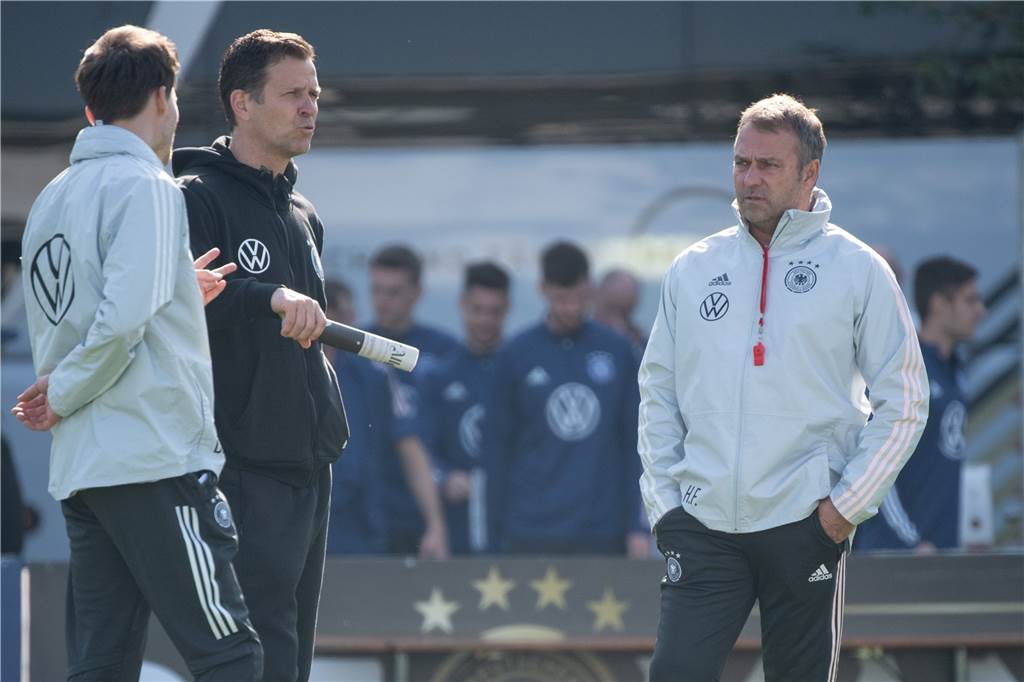 Oliver Bierhoff unf Hansi Flick stehen auf dem Trainingsplatz.