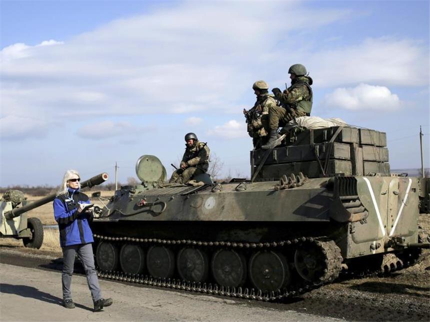 OSZE-Einsatz in der Ukraine soll massiv aufgestockt werden OSZE-Beobachterin vor ukrainischem Panzer. Künftig sollen deutlich mehr OSZE-Beobachter als bisher über den vereinbarten Waffenstillstand in der Ukraine wachen. Foto: Anastasia Vlasova