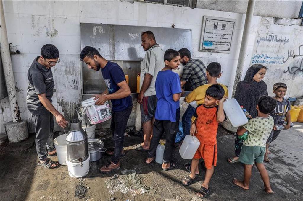 Israel: Massive Raketenangriffe aus Gazastreifen : Hamas startet „Militäroperation“ gegen Israel Palästinenser füllen an einem UN-Zentrum im Gazastreifen Flaschen mit Trinkwasser aus einem Wasserhahn. Foto: Abed Rahim Khatib/dpa