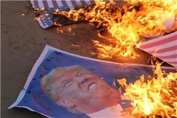 Palästinensische Demonstranten verbrennen Poster mit dem Konterfei des US-Präsidenten Trump. Foto: Ashraf Amra/APA Images via ZUMA Wire