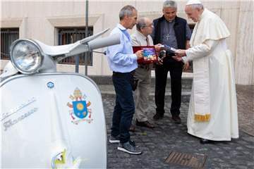 Papst Franziskus (r) bekam von Vertretern eines Vespa-Clubs aus Italien eine Vespa geschnekt. Foto: Vatican Media/