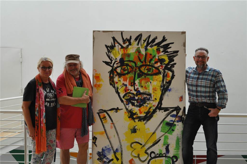 Beuys-Schüler Pascal Faber: Farbenfrohe Bilder aus verschiedenen Blickwinkeln Pascal Faber (2.v.l.) mit seiner Muse und Frau "Kitty" und Kulturbüroleiter Uwe Wortmann - sie rahmen ein Bild ein, das von Schamanen und den Maya inspiriert ist.