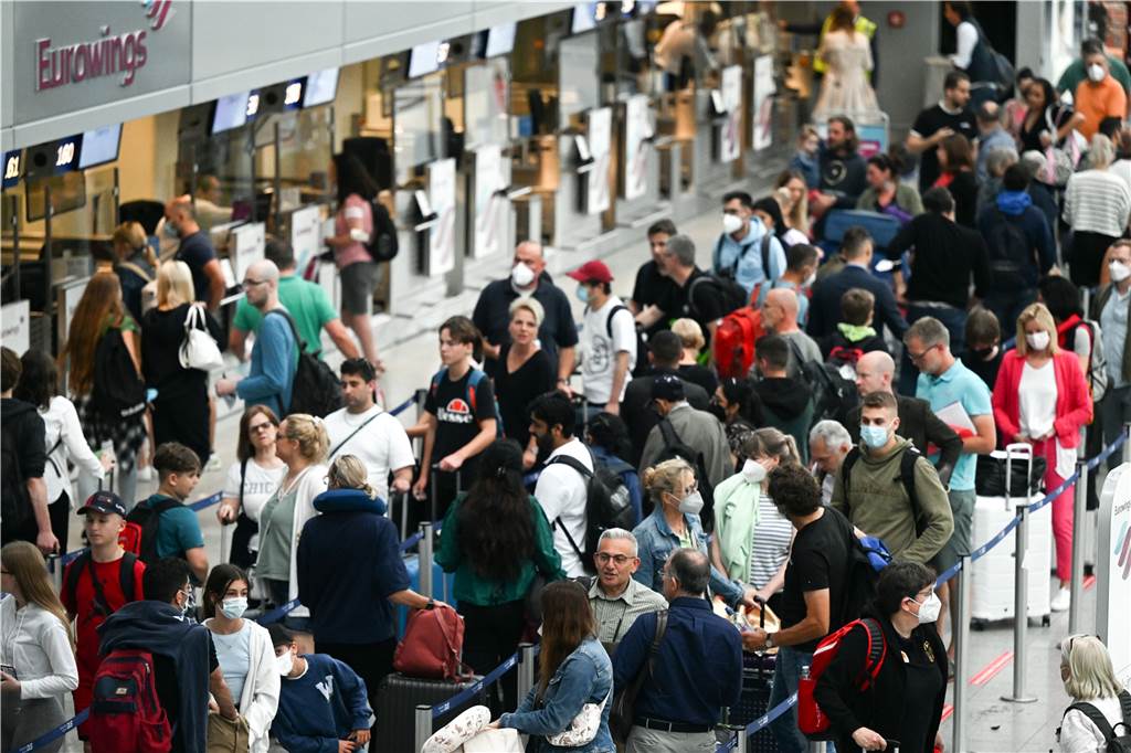 Sommerferien in NRW starten: Zeugnisse, Warteschlangen und Staus Passagiere warten an Eurowings-Schaltern auf dem Flughafen Düsseldorf auf ihre Abfertigung.