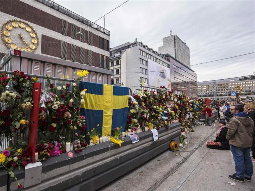 Stockholm setzt nach Anschlag Zeichen gegen Gewalt Passanten haben Blumen an einer Absperrung vor dem Stockholmer Kaufhaus Åhléns City befestigt. Foto: Kenta Jönsson/Bildbyran via ZUMA Wire