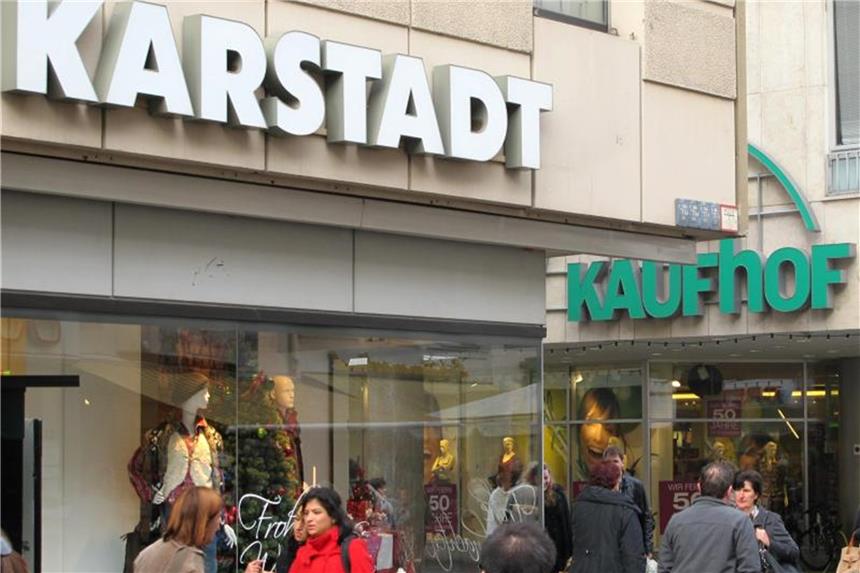 Passaten gehen an Filialen der Warenhausketten Karstadt und Kaufhof vorbei. Foto: Birgit Reichert/Illustration