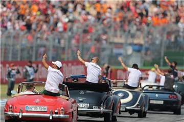Passend zum vorerst letzten Formel-1-Rennen in Deutschland defilieren die Rennfahrer in Oldtimern auf dem Hockenheimring am Publikum vorbei. Foto: Jan Woitas