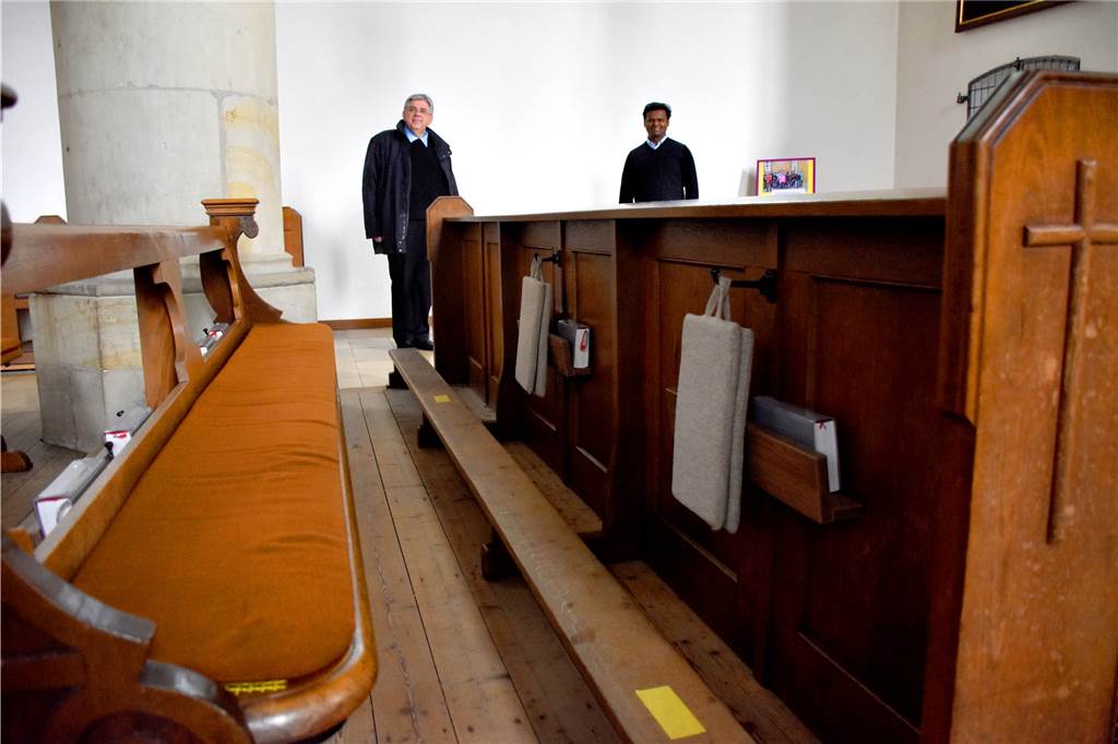 Pastor Stefan Scho (l.) und Pater Raju Peter im Mai bei einem Besuch der Redaktion in der Vituskirche: Die Sitzplätze in den Kirchenbänken sind mit gelben Klebestreifen markiert. Abstand halten ist Pflicht bei den Gottesdiensten.