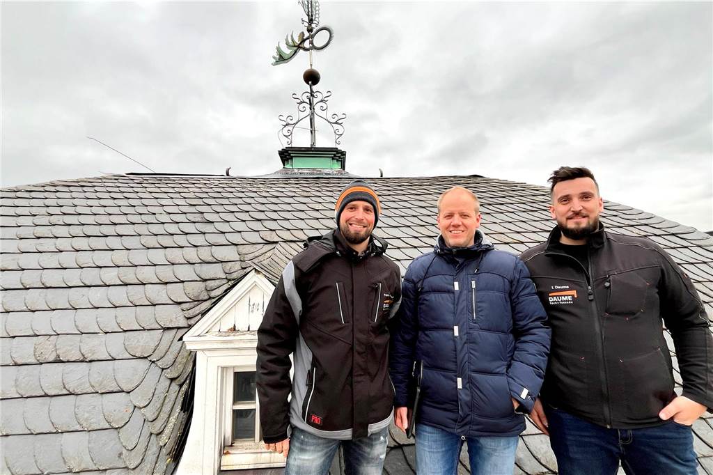 Patrick Hußmann, Benedikt Völker und Ingo Daume stehen vor dem Dach des Schlossturms.