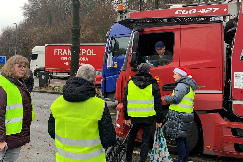 Weihnachtsüberraschung für Fernfahrer zieht Kreise Menschen stehen vor einem LKW