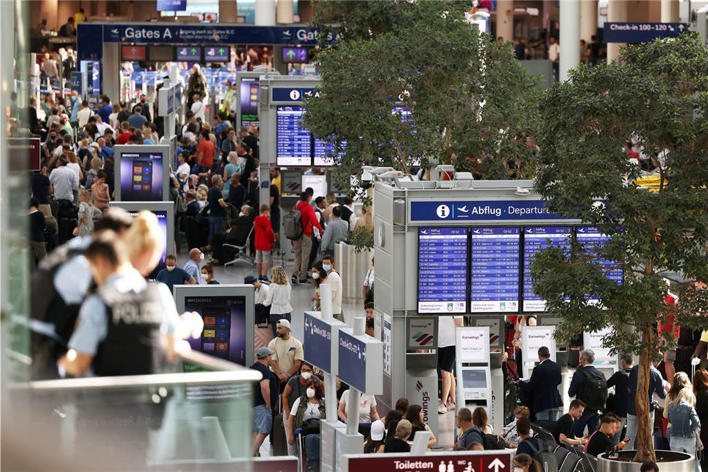Flughafenchaos zum Ferienstart: „Unser Urlaub ist gelaufen – wir fahren wieder nach Hause“ Passagiere stehen im Flughafen Düsseldorf in Schlangen und warten auf ihre Abfertigungen.