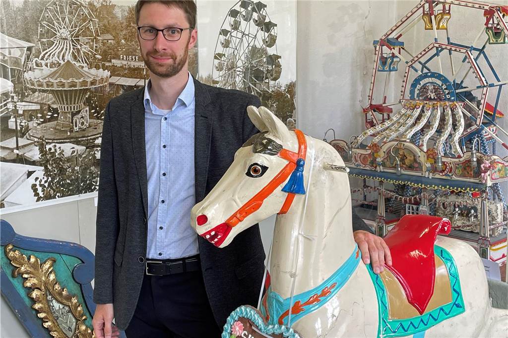Museumsleiter Flemming Feß steht neben dem Karussellpferd im Sim-Jü-Raum.