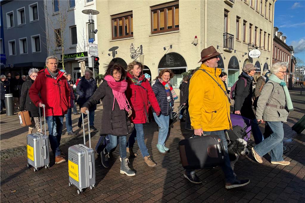 Teilnehmer mit Koffern in der Hand laufen durch die Stadt. 