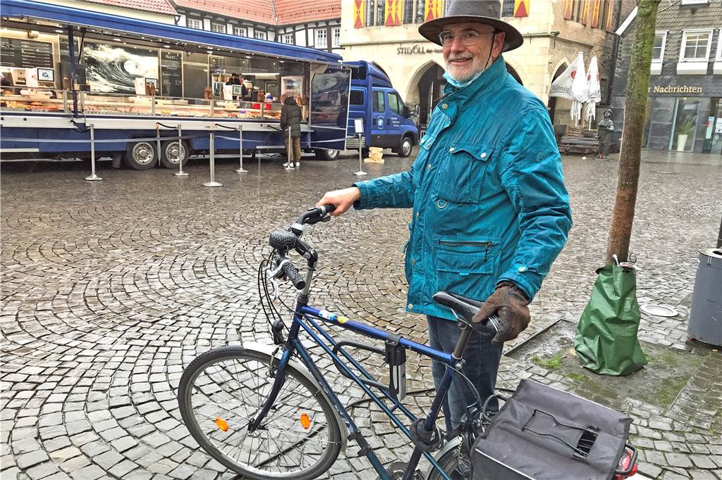 Hohe Spritpreise machen das Fahrrad attraktiv - Experte gibt Tipps Ein Mann steht mit seinem Fahrrad auf dem Marktplatz.