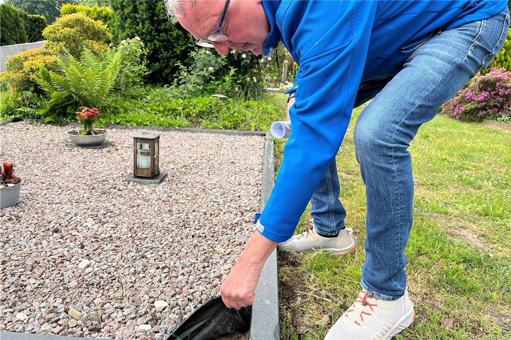 Sixtus-Friedhof: Gräber werden immer öfter mit Schotter zugeschüttet Peter Rütter hebt Vlies am Grab hoch.