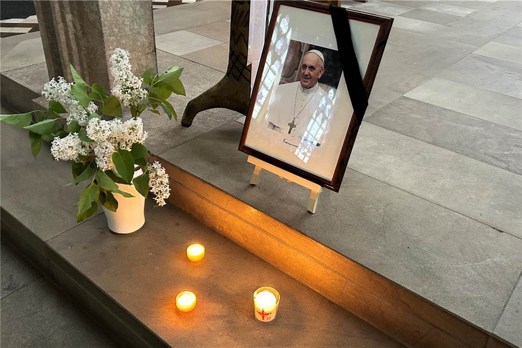 Pfarrer Schäfer betete für Papst Franziskus: „Gespannt, wie es weitergeht“ Ein Bild von dem verstorbenen Papst Franziskus steht in der St.-Marien-Kirche in Lünen, daneben drei Kerzen und eine Vase mit weißen Blumen.