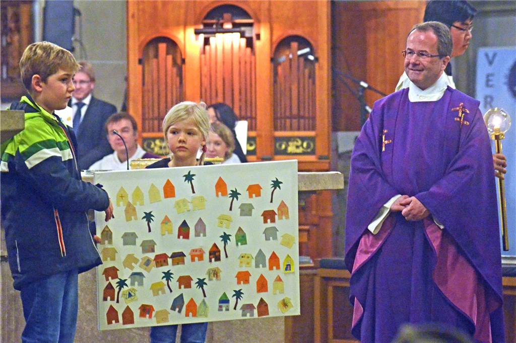 Pfarrer Michael Mombauer freute sich am Ende seines Einführungsgottesdienstes am ersten Advent 2018 über Kinder, die ihm ein in der Kinder-Kirche gemaltes Bild mit biblischem Inhalt zeigten.