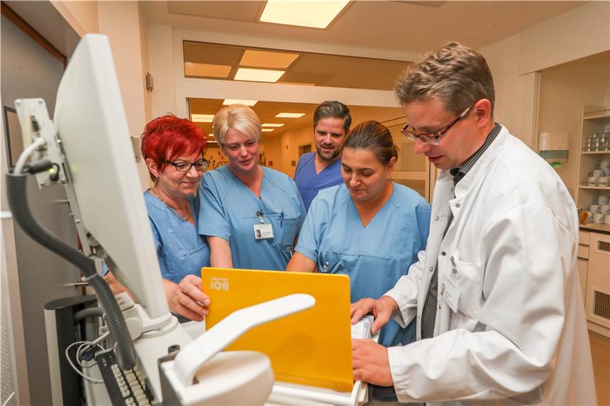 Tag und Nacht an der Seite der Patienten Pflegestationsleiter Christian Schönweitz (hinten) bespricht mit seinem Team die Aufgaben für den Tag. Foto: Schütze