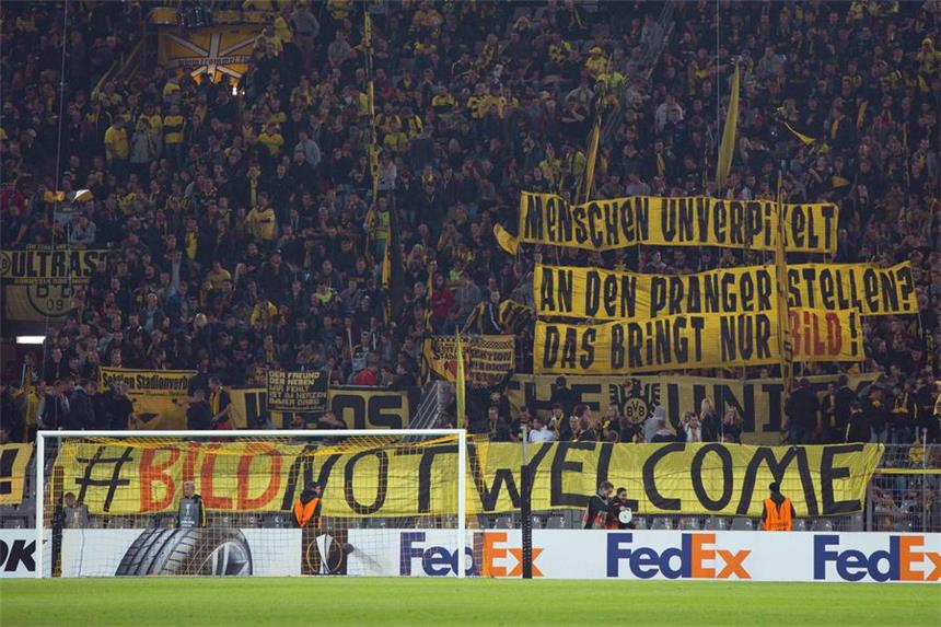 BVB nimmt an umstrittener Aktion "Wir helfen" teil Plakate der BVB-Fans vor dem Spiel gegen Krasnodar.